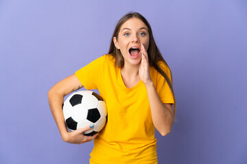 Young Lithuanian football player woman isolated on purple background with surprise and shocked...