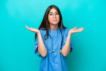 Young nurse caucasian woman isolated on blue background having doubts while raising hands
