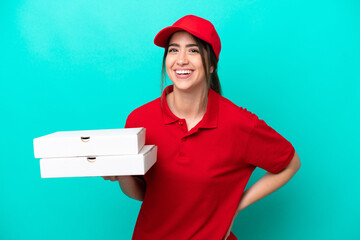 Pizza delivery woman with work uniform picking up pizza boxes isolated on blue background smiling a...