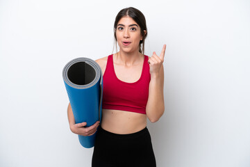 young sport woman going to yoga classes while holding a mat isolated on white background intending to realizes the solution while lifting a finger up