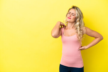 Young Brazilian woman isolated on yellow background suffering from pain in shoulder for having made an effort
