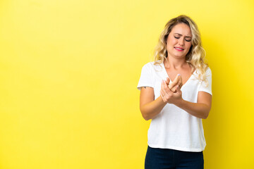 Young Brazilian woman isolated on yellow background suffering from pain in hands