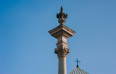 Fototapeta na wymiar Ancient medieval column of the Bernardine church in Lvov, Ukraine. Blue sky and a cross on the roof.
