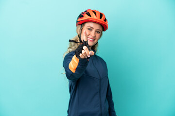 Young cyclist woman isolated on blue background showing and lifting a finger