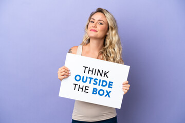 Young Brazilian woman isolated on purple background holding a placard with text Think Outside The Box