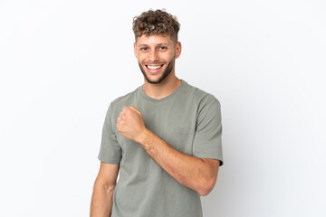 Young caucasian handsome man isolated on white background celebrating a victory