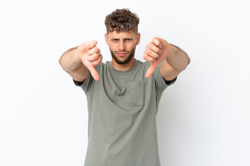 Young caucasian handsome man isolated on white background showing thumb down with two hands