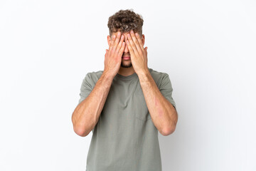 Young caucasian handsome man isolated on white background covering eyes by hands