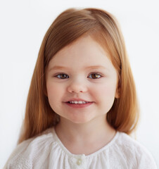 portrait of smiling redhead baby girl, 3 years old