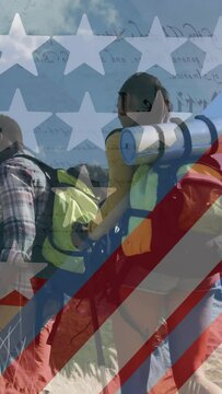 Animation of american flag over smiling diverse couple hiking in mountains