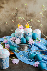 Beautiful Easter cakes in glaze and confectionery sprinkles and candles. Easter traditional treats and festive table decor