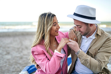 Young couple in love sitting in a boat on the beach