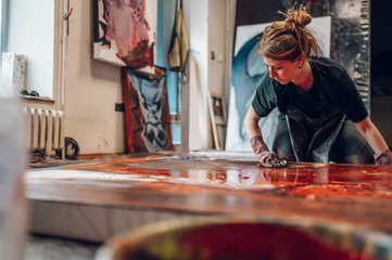 Fotobehang Schilderij Female painter artist painting and creating her art in a creative studio  © Zamrznuti tonovi