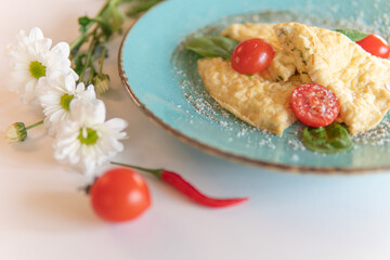 Scrambled eggs with bacon tomatoes and herbs on a white table