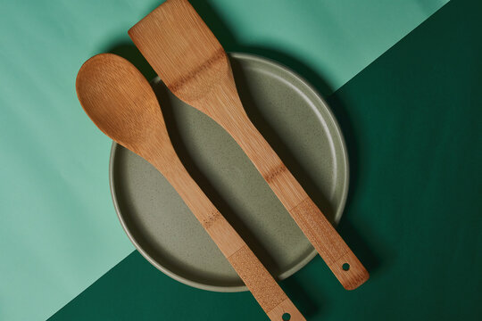 Green backgrounds with food utensils. Bottles, glasses, plates. Wooden objects.