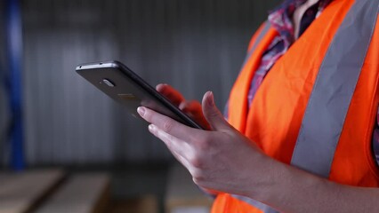 Business concept of 4k Resolution. An employee is checking the goods with a tablet in the warehouse. - Powered by Adobe
