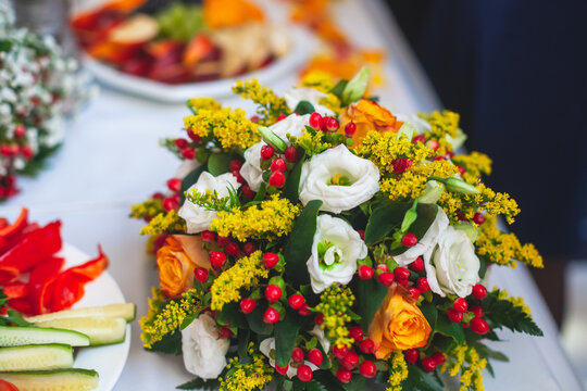 Beautiful table decoration in orange autumn fall colours, table arrangement on event in a restaurant with flowers, bouquet, berries, fruits and leaves on a wedding reception banquet party
