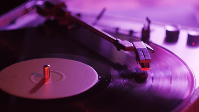Vinyl record close-up. Vintage old vinil black phonograph spinning. Retro music player on living room home background in evening.