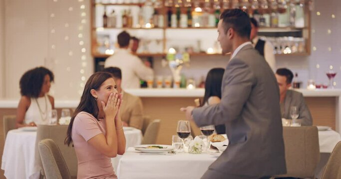 Hes proposing at the same place they had their first date. 4k video footage of a man proposing to his girlfriend while on a date at a restaurant.