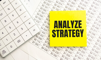 ANALYZE STRATEGY text on paper with calculator, magnifier ,pen on the graph background