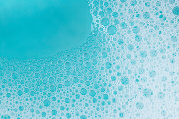 foam bubbles.Blue water with white foam bubbles.Foam Water Soap Suds. blue soap bubbles background. - obrazy, fototapety, plakaty