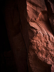 A corner of sandstone in the Texas desert. Red Rock in the American southwest, shadows and light. Rock wall, stones casting shadows in a desert cave.