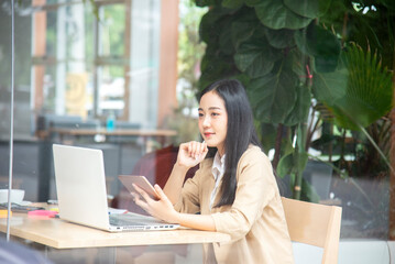 Happy businesswoman using laptop in the office.woman working on a laptop in cafe.