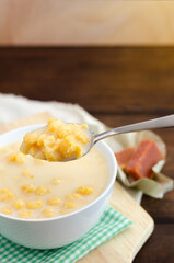 Traditional Colombian food called mazamorra,based on cooked corn dissolved in milk,accompanied with sweet guava(called a bocadillo). Dark wooden background. Close up. 