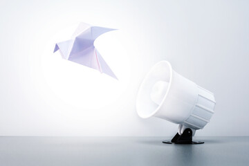  Megaphone with paper dove on grey background.  Concept of peace, free speech.