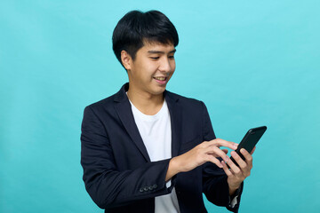 Young Asian man in a semi-formal suit using a mobile phone