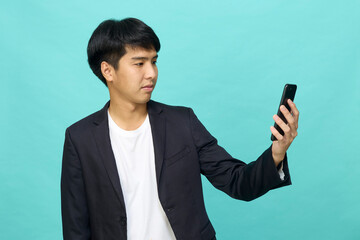 Young Asian man in a semi-formal suit using a mobile phone