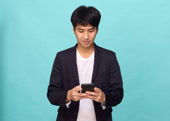 Young Asian man in a semi-formal suit using a mobile phone