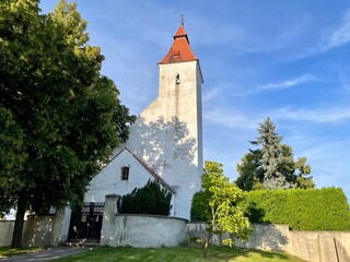 Fototapeta premium Church of the Nativity of St. John the Baptist, built in Romanesque style with a Baroque extension. In the village of Hovorcovice near Prague. High quality photo