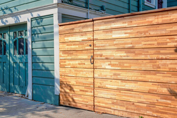 Wooden gate and fence beside the house with blue green exterior at San Francisco, California