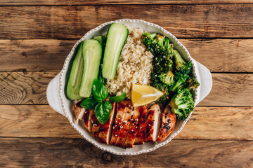 Keto lunch bowl. Grilled chicken with cauliflower rice, broccoli and cucumber.