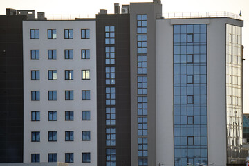Architectural details of modern high apartment building facade with many windows and balconies