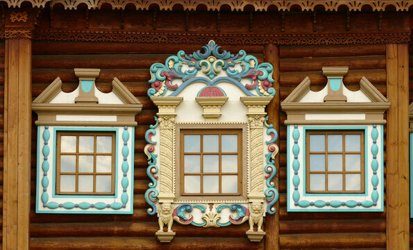 Russian carved wooden frames beautify exterior of timbered house.