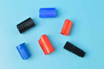 Marker pen caps in a row isolated on a blue background
