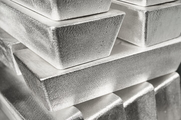 Stack of industrial silver ingots at bright light in storage