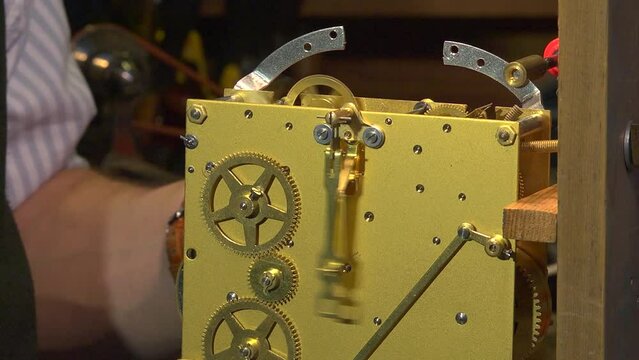 Clockmaker testing a clock mechanism, closeup