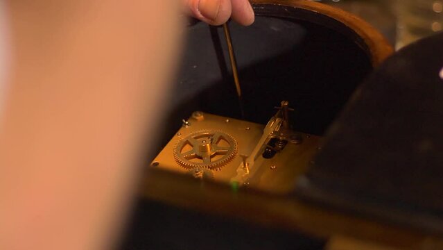 Clockmaker connecting the mechanism of a clock to its case