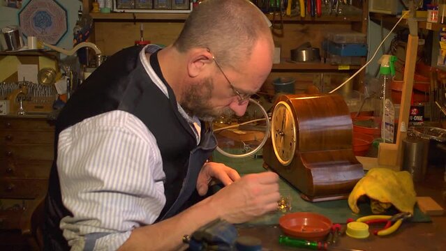 Clockmaker collecting tools together for repairing a clock