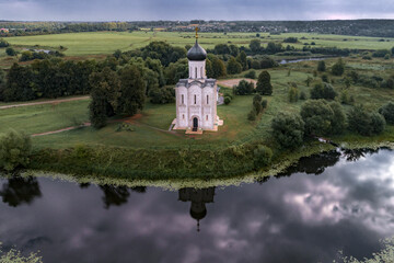 Ancient Church of the Intercession on the Nerl on the early cloudy morning. Neighborhood of the...