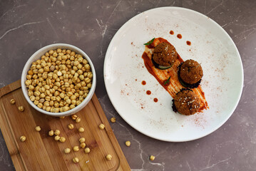 Roasted vegan chickpeas meatballs in tomato sauce.