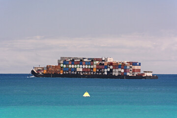 Importing of an overloaded inter-island container ship off Honolulu Harbor in Hawaii
