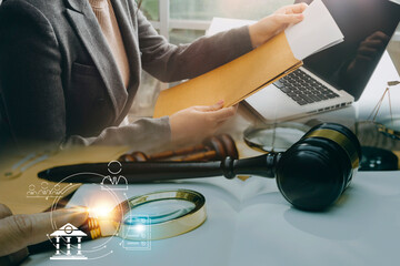 Justice and Law concept. Legal counsel presents to the client a signed contract with gavel and legal law or legal having team meeting at law firm in background