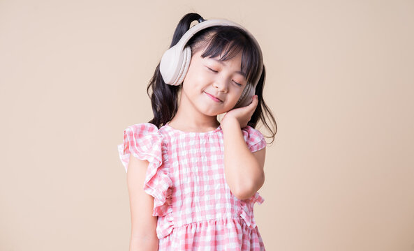 Image of Asian child listening music on background