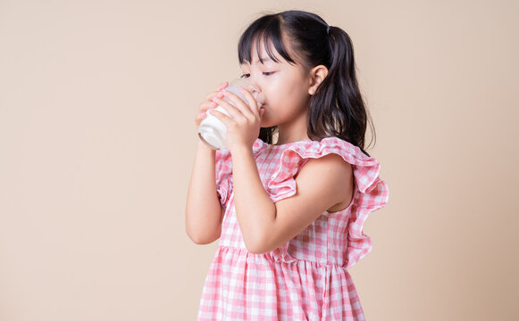 Image of Asian child drinking milk on background