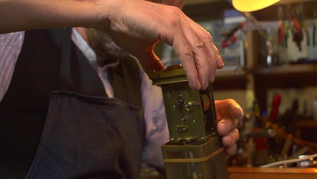 Clockmaker working on a carriage clock - replacing the case