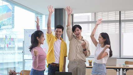 Obraz premium Successful business team celebrating corporate victory together in office.